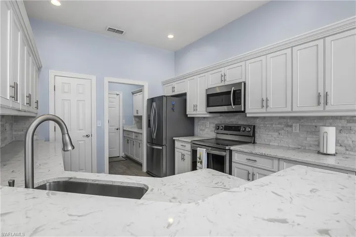 Across quartz countertops leading to utility room.