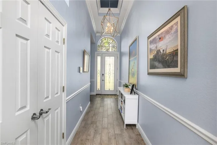 Entry foyer with leaded glass front door, new lighting and new luxury vinyl plank flooring throughout. Double door storage closet is to left.