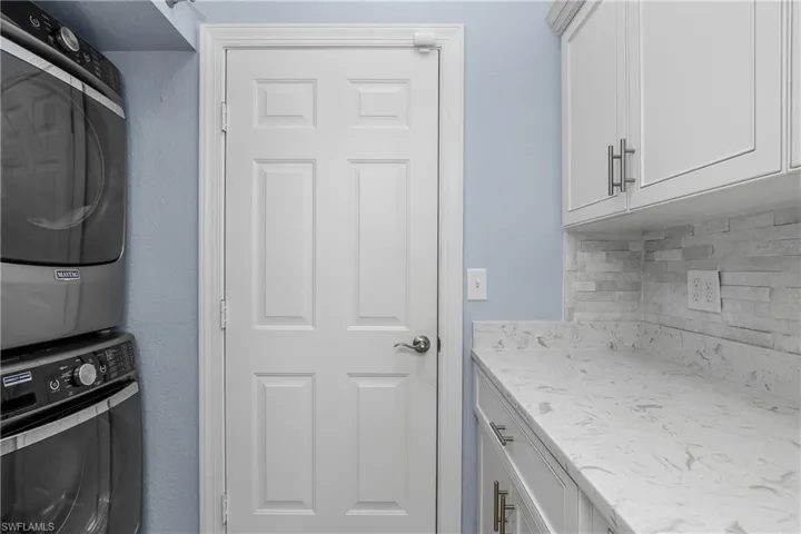 Maytag stacked washer / dryer, door to garage.