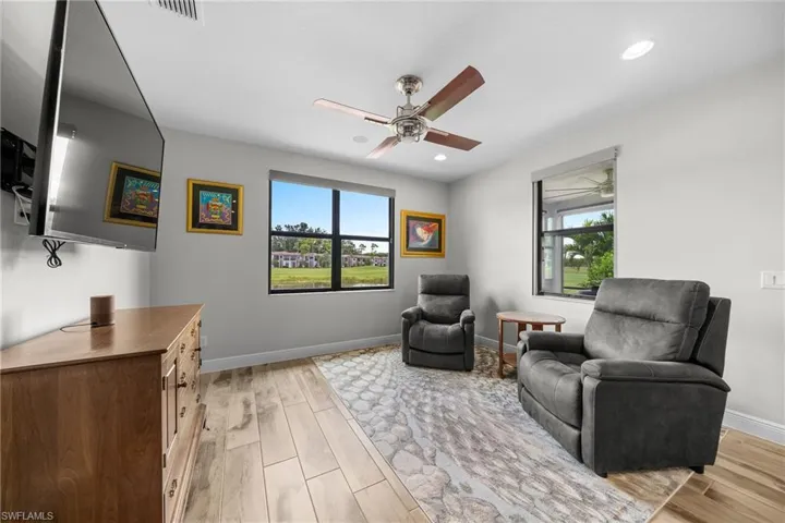 Living area with light wood-style floors, a ceiling fan, plenty of natural light, and recessed lighting