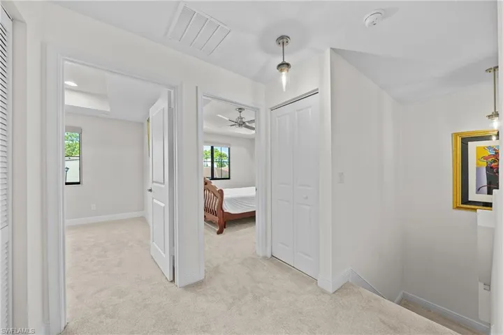 Hall featuring light carpet and baseboards