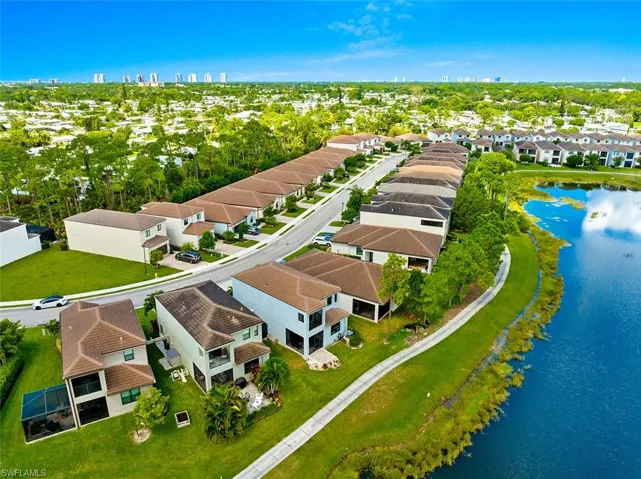 Aerial perspective of suburban area featuring a large body of water and skyline