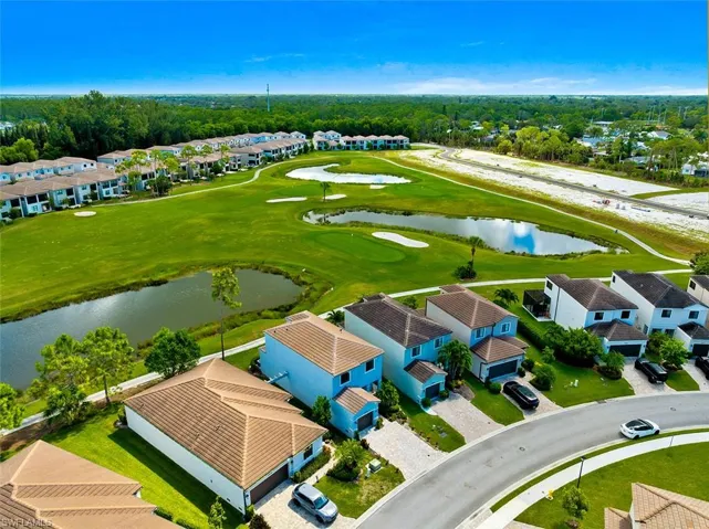 Aerial view of residential area with a nearby body of water and a local golf course