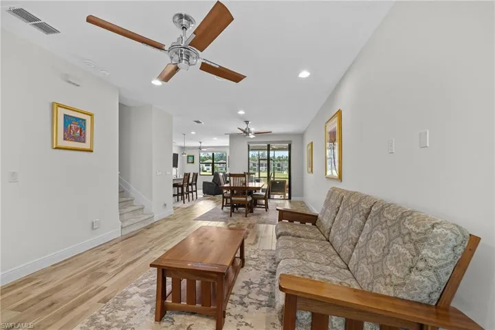 Living room with light wood-type flooring, recessed lighting, and a ceiling fan