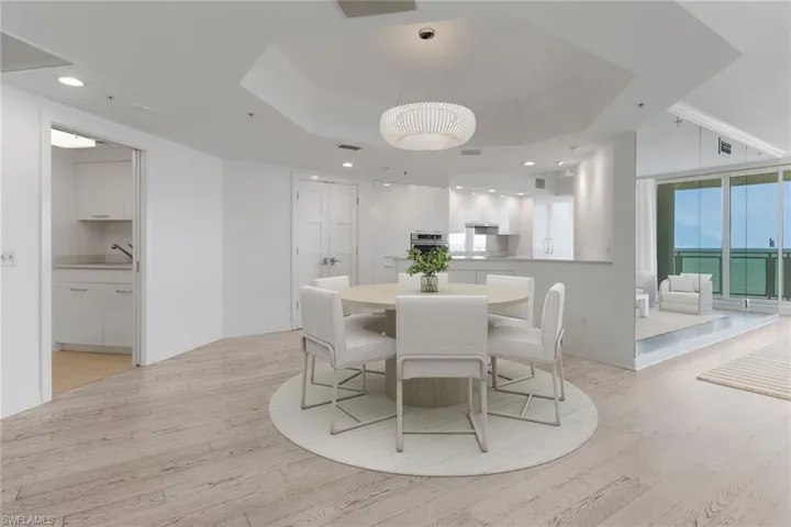 VIRTUAL STAGED Dining area featuring light wood-type flooring, a tray ceiling, and recessed lighting