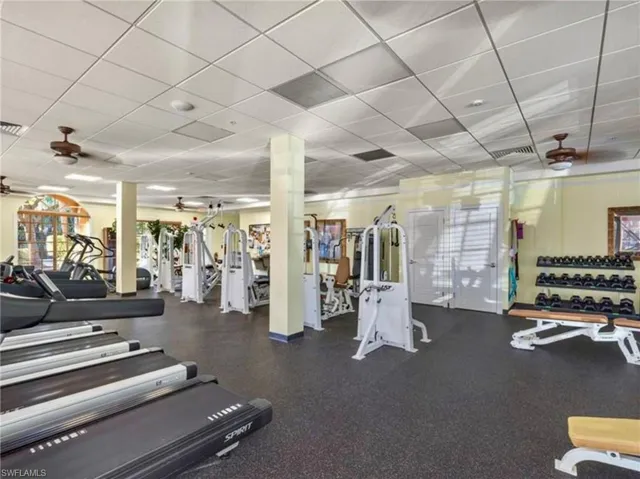 Workout area with visible vents, ornate columns, and a drop ceiling