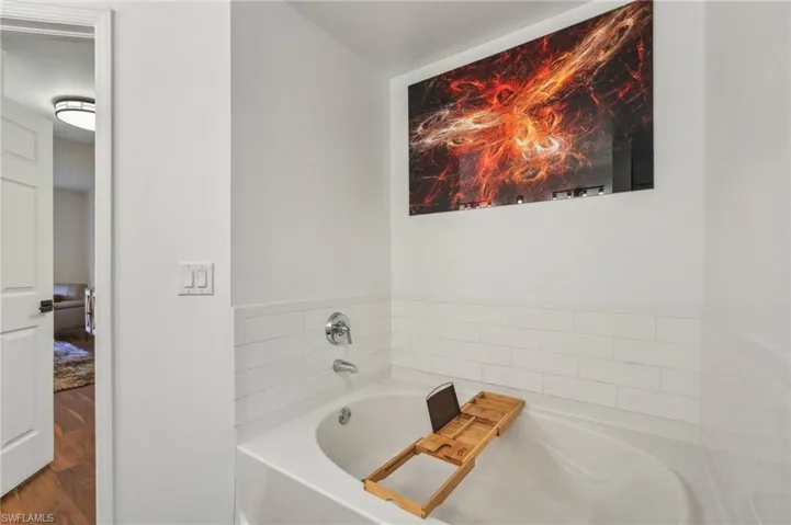 Full bathroom with a garden tub and wood finished floors