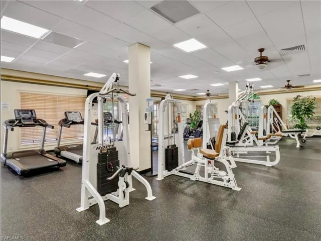 Workout area featuring visible vents, a drop ceiling, and a ceiling fan