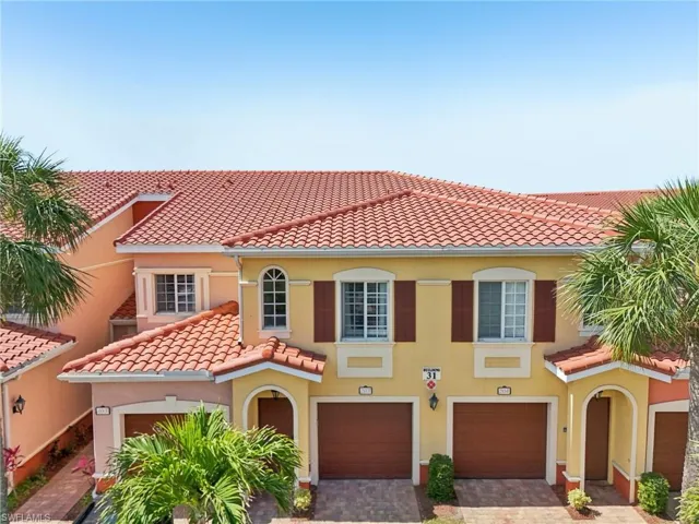 Mediterranean / spanish house with stucco siding, a tile roof, an attached garage, and decorative driveway