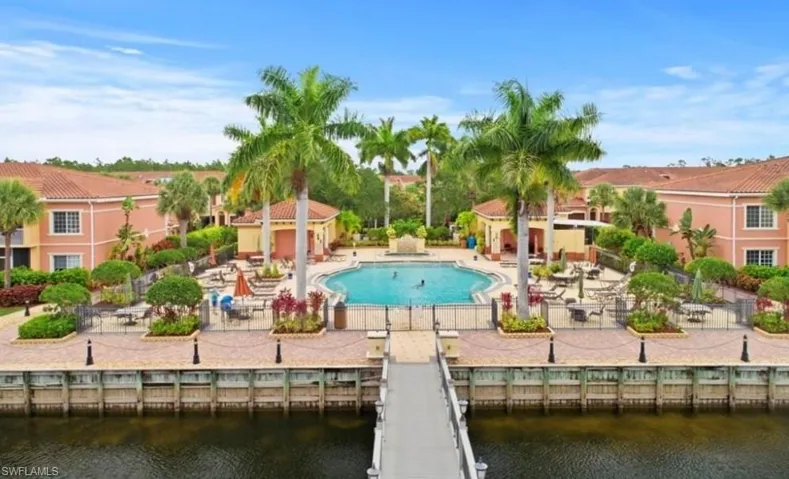 View of pool with a patio, a water view, and fence