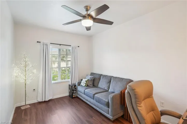 Living room with a ceiling fan, baseboards, and dark wood finished floors