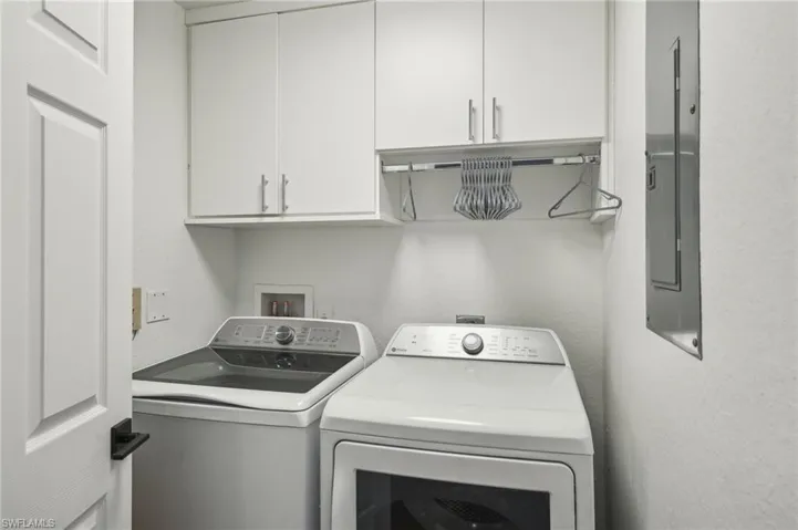 Washroom with cabinet space and washer and clothes dryer