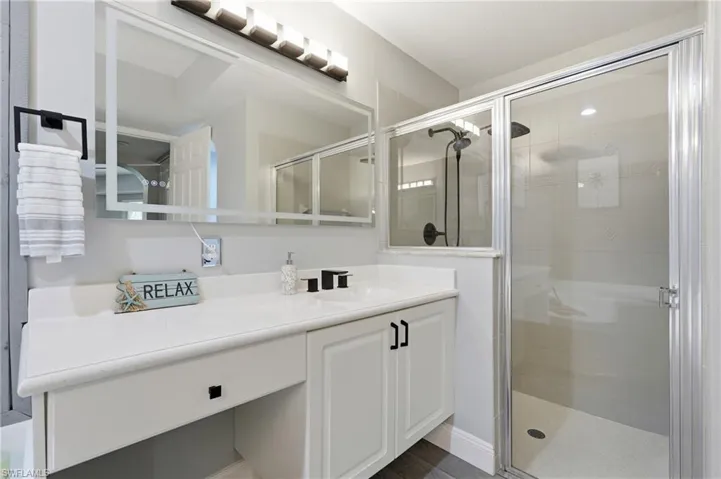 Vanity with integrated sink, white cabinetry, and matte black fixtures