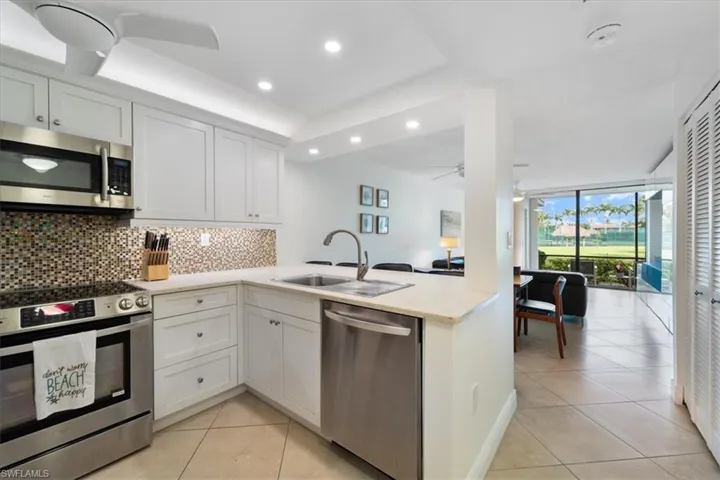 Kitchen featuring appliances with stainless steel finishes, light tile patterned floors, white cabinetry, decorative backsplash, and recessed lighting