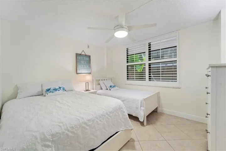 Bedroom featuring light tile patterned flooring, a textured ceiling, and ceiling fan