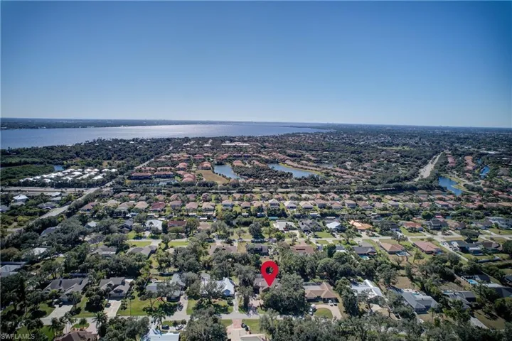 Aerial view of property and surrounding area with nearby suburban area and a large body of water