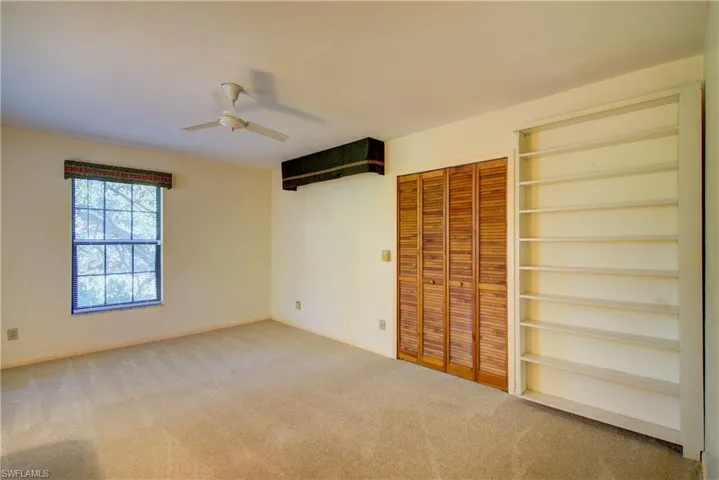 Unfurnished bedroom featuring a closet, carpet flooring, and a ceiling fan