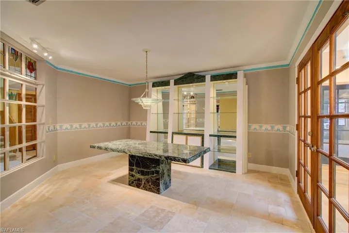 Unfurnished dining area with crown molding and stone tile flooring