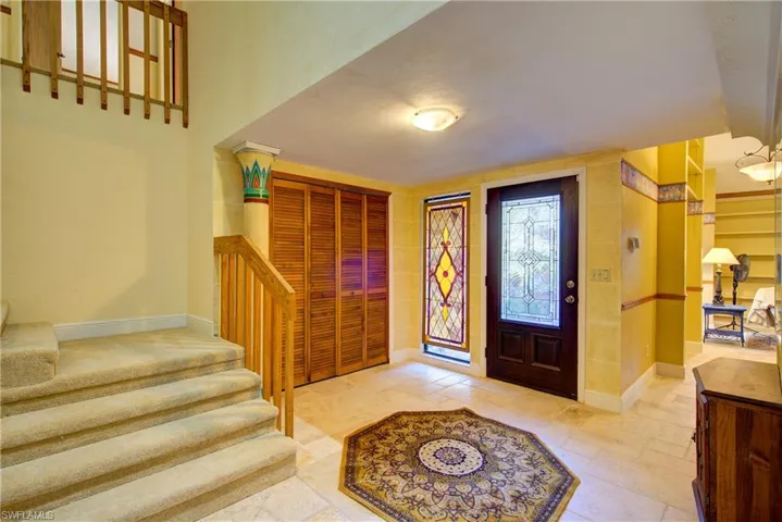 Entrance foyer featuring stairs and stone tile flooring