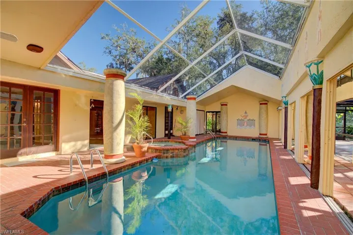 View of swimming pool featuring a patio area, a lanai, a sunroom, and french doors