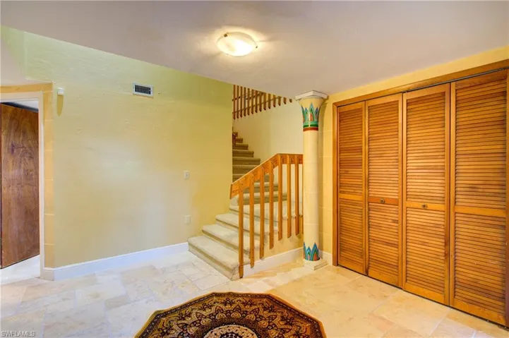 Stairway featuring stone tile floors and baseboards