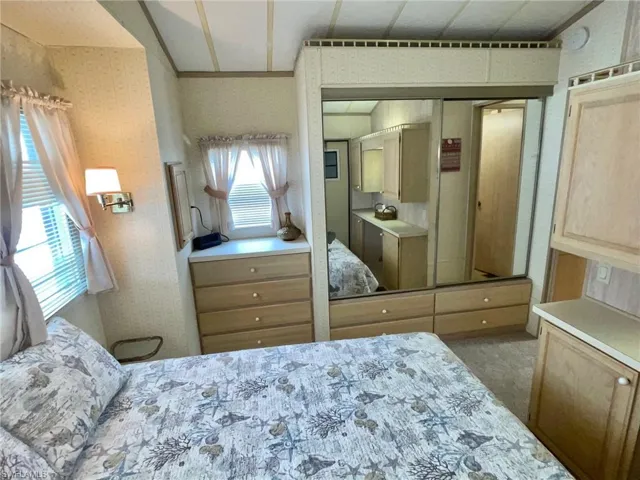 Bedroom featuring a closet and wallpapered walls