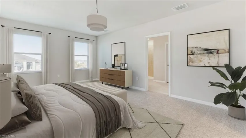 Bedroom featuring light carpet and baseboards