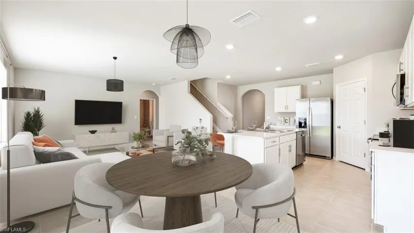 Dining area featuring arched walkways, recessed lighting, and light tile patterned floors