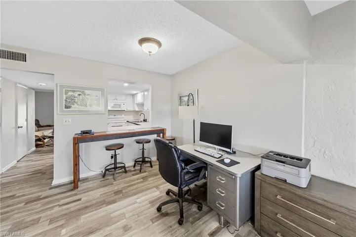 Office space with a textured ceiling and light wood-type flooring