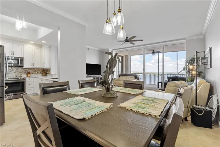 Tiled dining room with expansive windows, ceiling fan, and ornamental molding