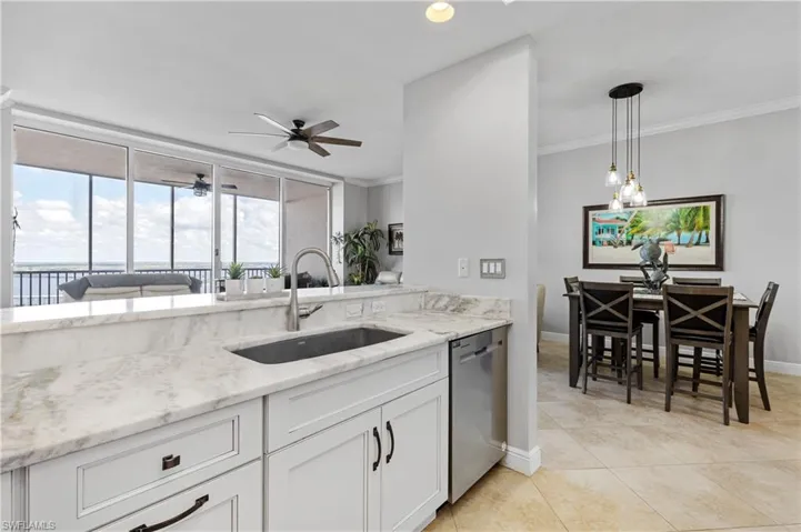 Kitchen with sink, ornamental molding, dishwasher, pendant lighting, and white cabinets