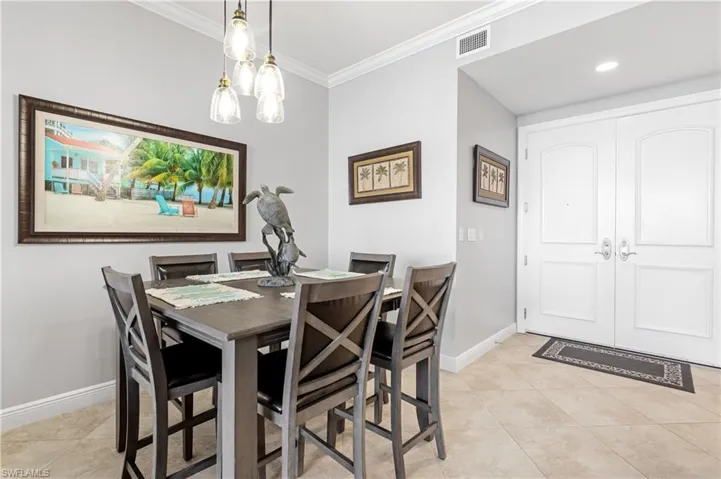 Dining space featuring light tile patterned flooring and ornamental molding