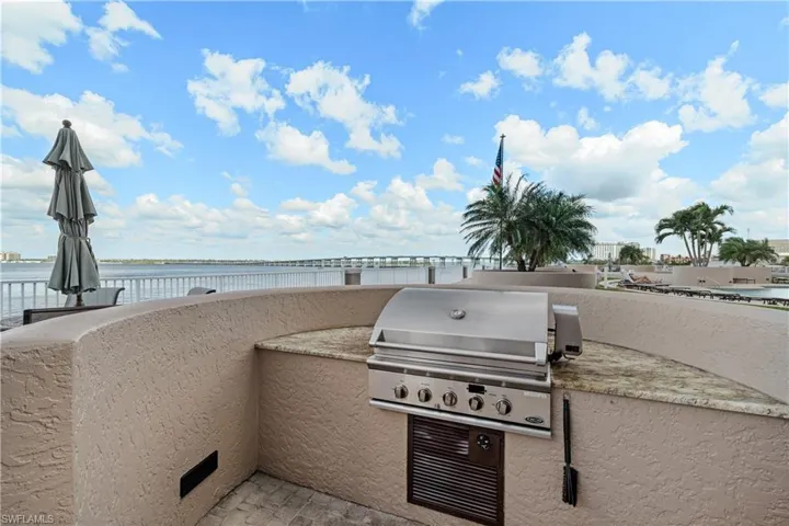 View of patio / terrace with a water view, an outdoor kitchen, and area for grilling