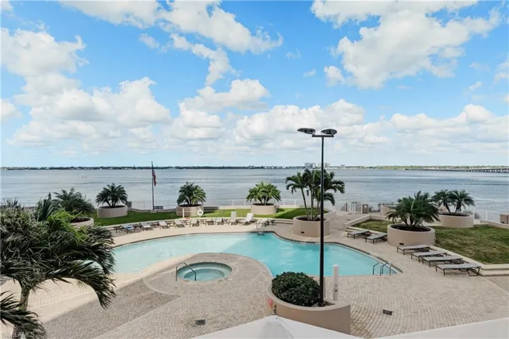 View of pool featuring a water view, a patio area, and a community hot tub