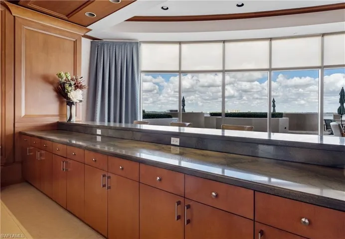 Community room Kitchen with plenty of natural light and dark stone counters
