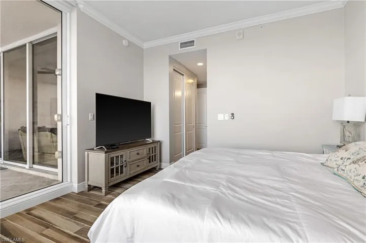 Bedroom with ornamental molding and access to outside