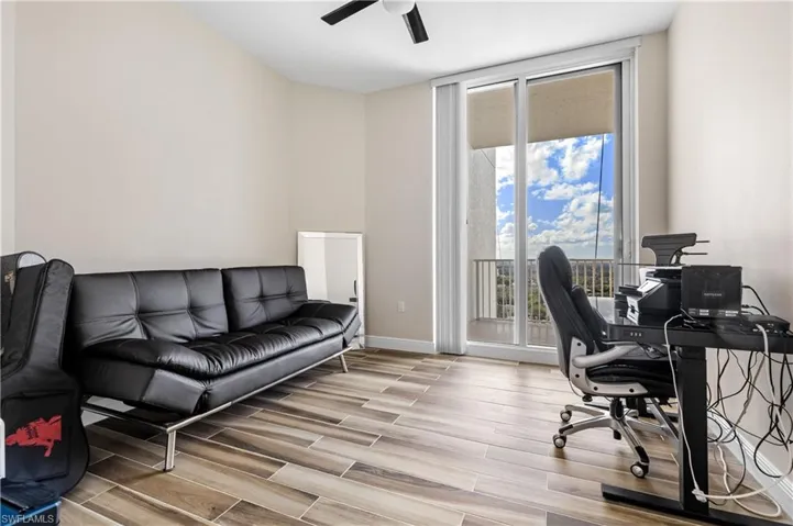 Home office with floor to ceiling windows and ceiling fan