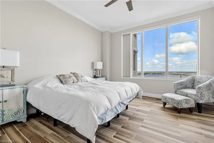 Bedroom featuring ornamental molding, a water view, and ceiling fan
