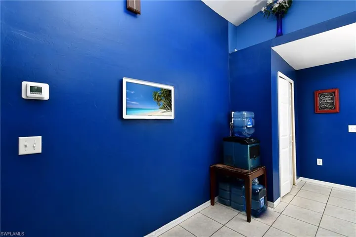 Hallway with tile patterned flooring and baseboards