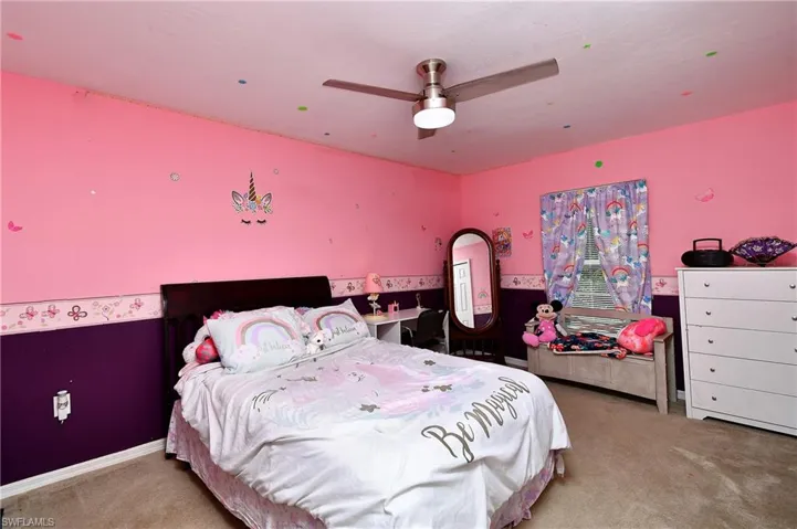 Carpeted bedroom featuring ceiling fan