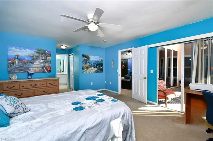 Bedroom with a closet, light carpet, access to exterior, and a ceiling fan