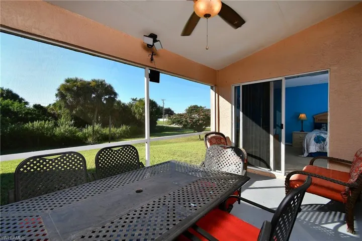 Sunroom with vaulted ceiling, outdoor dining space, a patio, and a ceiling fan