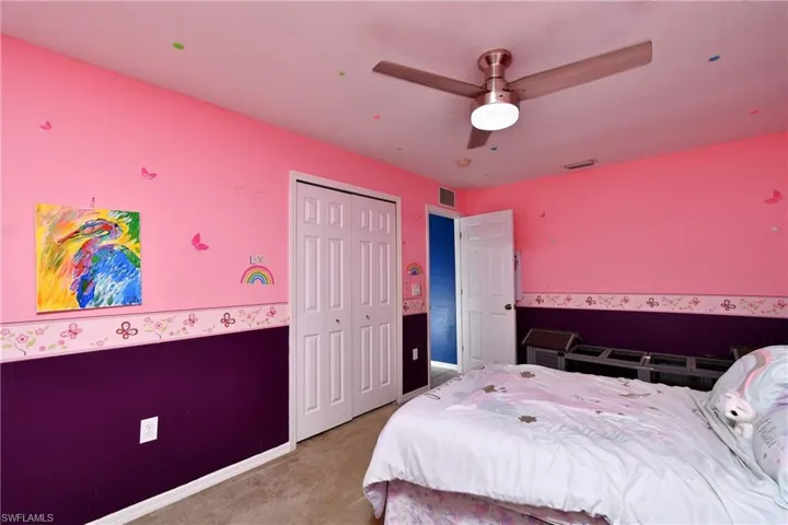 Carpeted bedroom featuring a closet and a ceiling fan