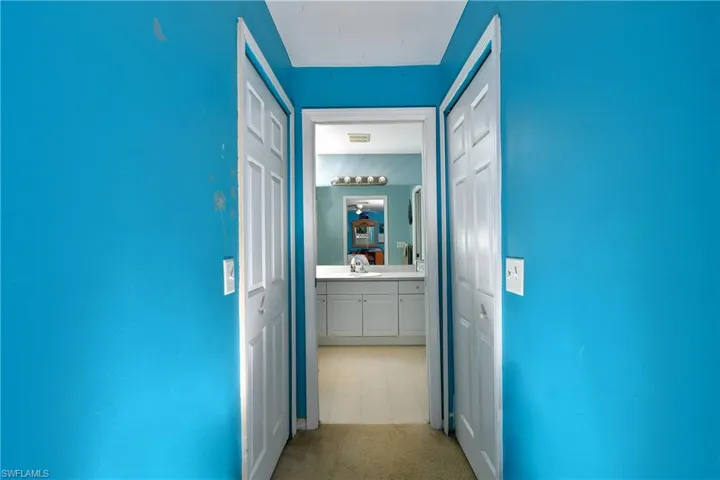 Hall with light colored carpet and a sink