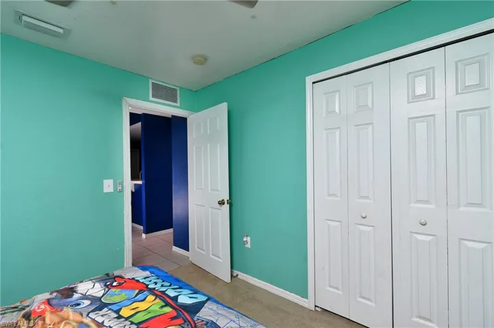 Carpeted bedroom featuring baseboards and a closet