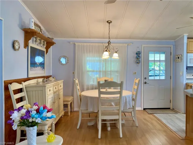 DINING ROOM with crown molding, light wood-type flooring, and a chandelier