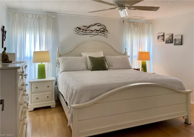 MASTER BEDROOM featuring walk-in closet, multiple windows, light wood-type flooring and ceiling fan