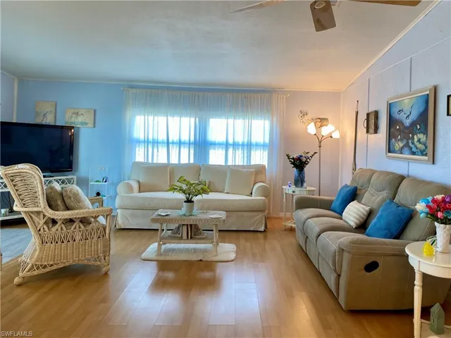 LIVING ROOM featuring ceiling fan, vaulted ceiling, and wood-style floors