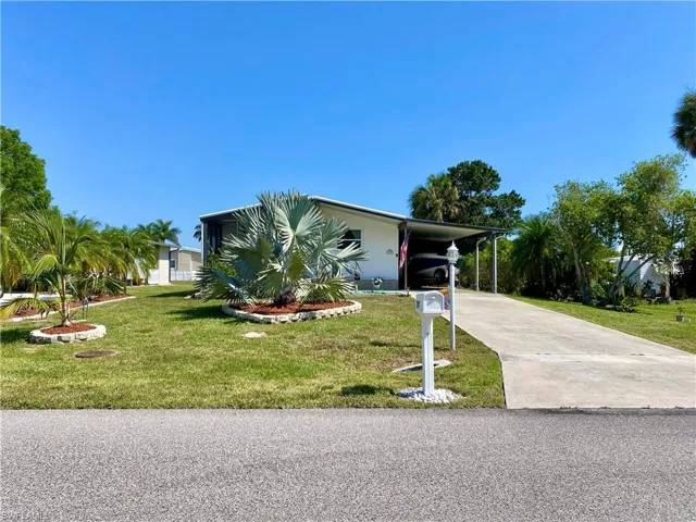 View of front of property with a front lawn and a carport