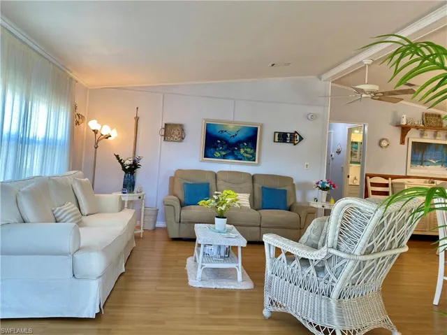LIVING ROOM with ceiling fan, vaulted ceiling and wood-style flooring